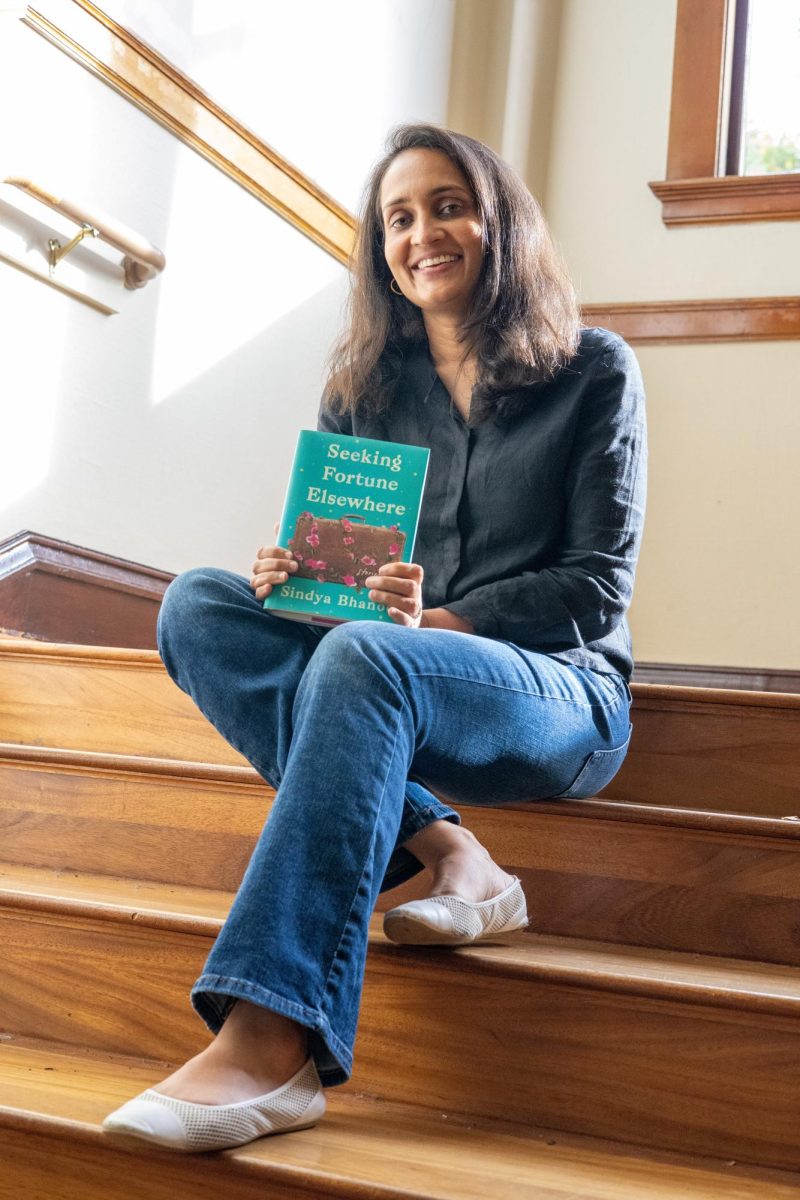 Sindya Bhanoo (she/her), an assistant professor at Oregon State University’s School of Writing, Literature and Film, poses for a photograph with her book “Seeking Fortune Elsewhere” on Oct 17 at OSU’s Moreland Hall. Bhanoo’s book was nominated for, and won, the New American Voices literary award in 2022.