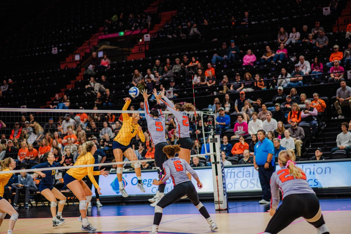 Aliyah McDonald (#5) and Megan Sheridan (#21) block an attack on Oct. 22, 2023 from the California Bears in Gill Coliseum.