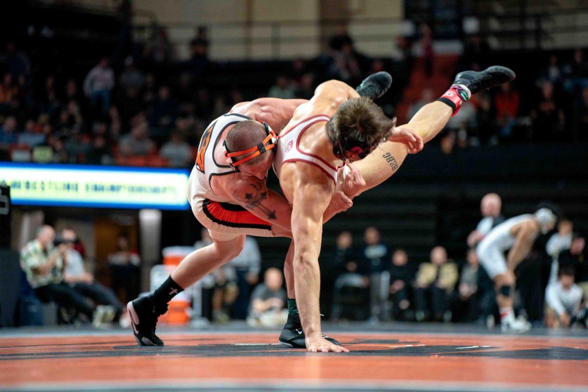 Nash Singleton throws his opponent to the ground during the Pac-12 Wrestling Championship at Gill Coliseum in Corvallis on Sunday.
