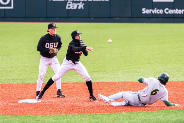 Jabin Trosky (2) throws the ball to first base as NDSU player (6) slides into second base at Goss Stadium at Coleman Field on March 3 in Corvallis, Oregon.