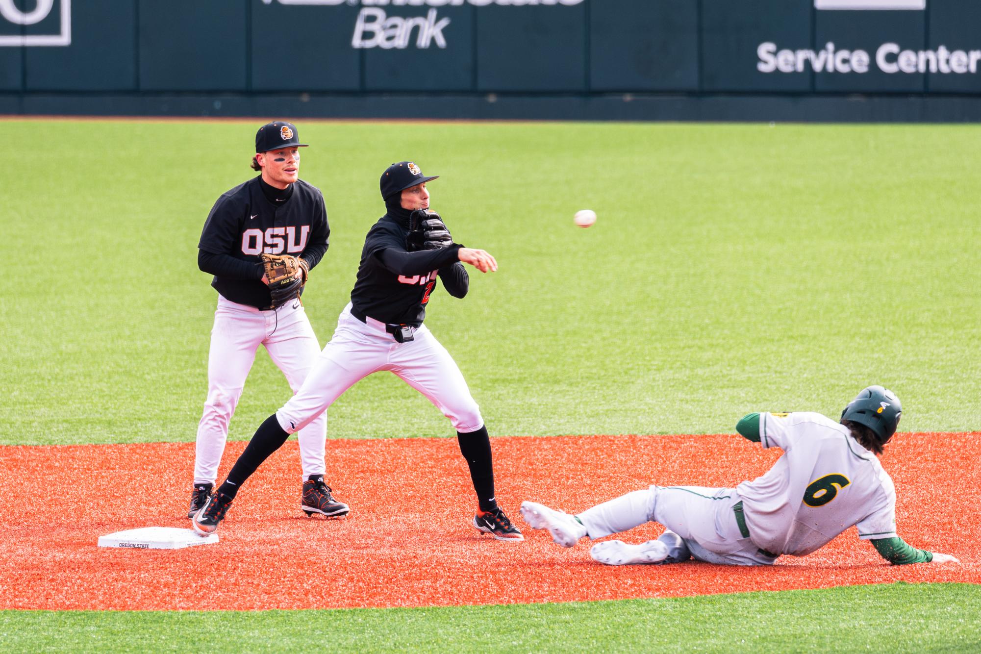 Jabin Trosky (2) throws the ball to first base as NDSU player (6) slides into second base at Goss Stadium at Coleman Field on March 3 in Corvallis, Oregon.