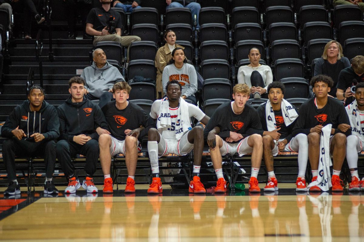 The OSU mens basketball team watches on as they play Cal Poly on Dec. 4, 2023.