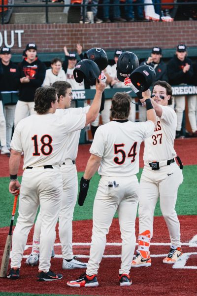 Travis Bazzana does a helmet bump celebration with his teammates after hitting his OSU record breaking 35th career home run in a game against the University of Portland at Goss Stadium in Corvallis on Tuesday, April 9.