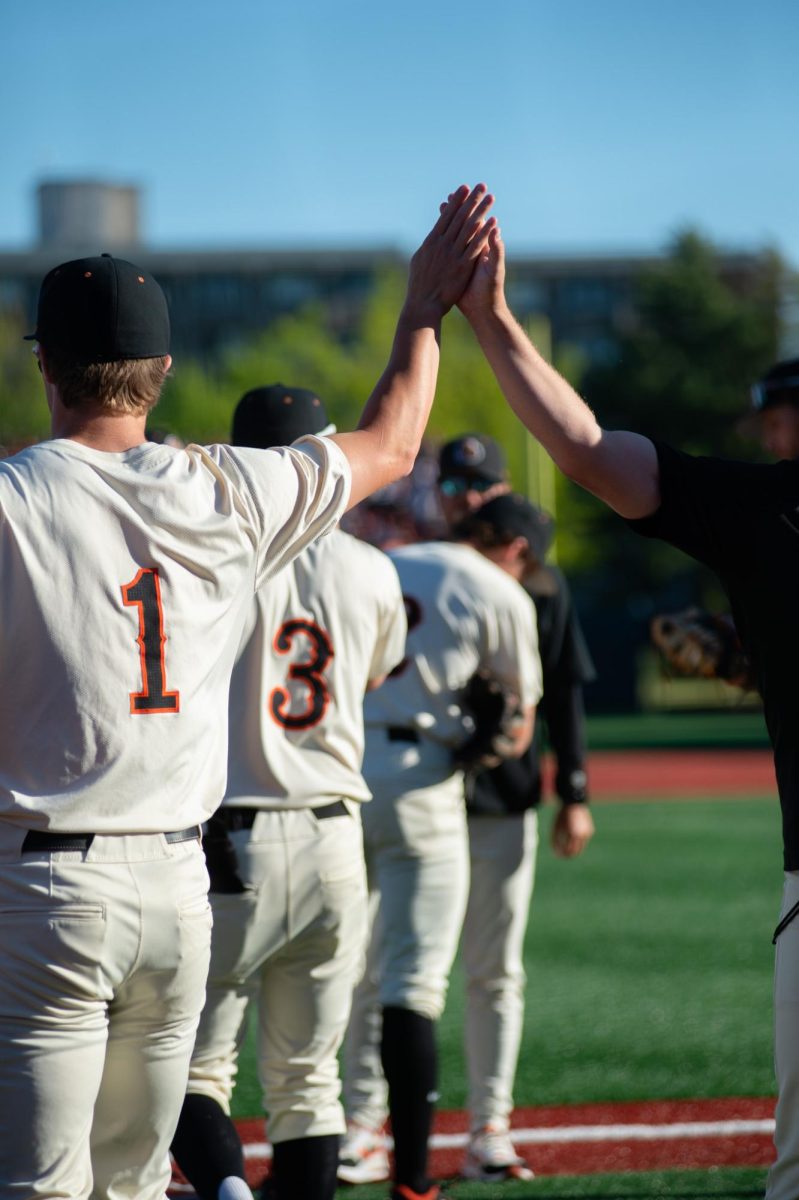 Gavin Turley (#1) high fives one of his coaches during an inning break at the OSU v UCLA baseball game in Goss Stadium at Oregon State on May 11, 2024.