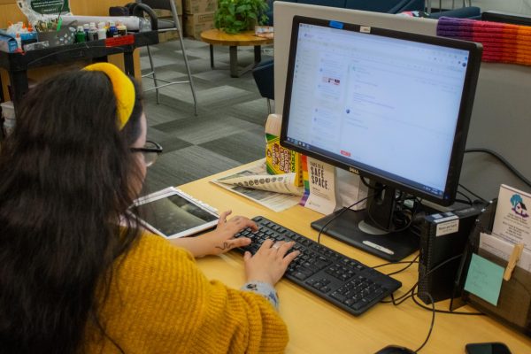 Vee Escobar works at her desk in the Pride Center, which is located in the Student Experience Center at Oregon State University. She found the Pride Center to be a safe and comforting space when overwhelmed with school.