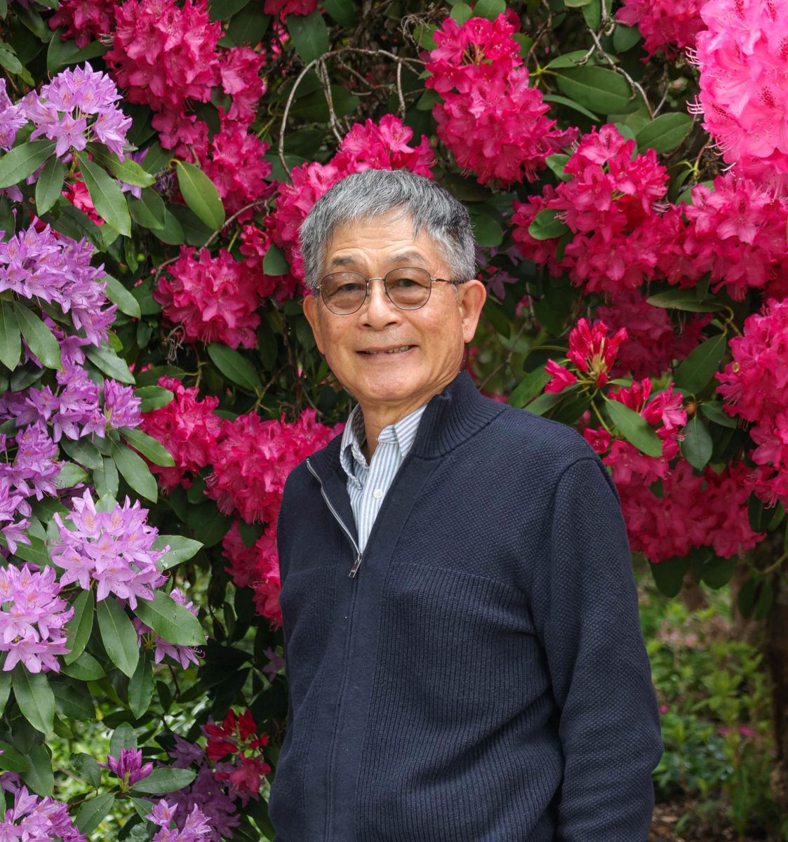 Chunhuei Chi poses for a portrait in front of rhododendron bushes on the Oregon State University campus in Corvallis, Oregon on May 7, 2024. 
