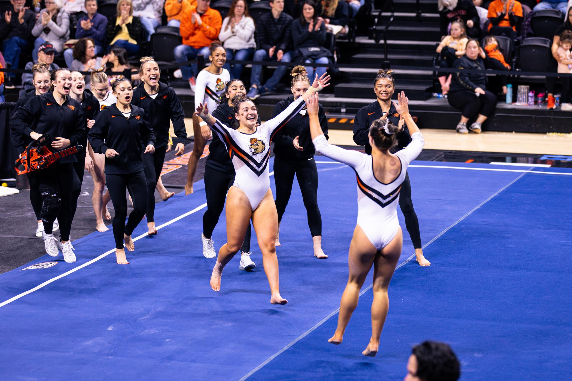 Beaver Women’s Gymnastics team runs up to congratulate fellow Beaver gymnast on March 1 at Gill Coliseum in Corvallis, Oregon. 