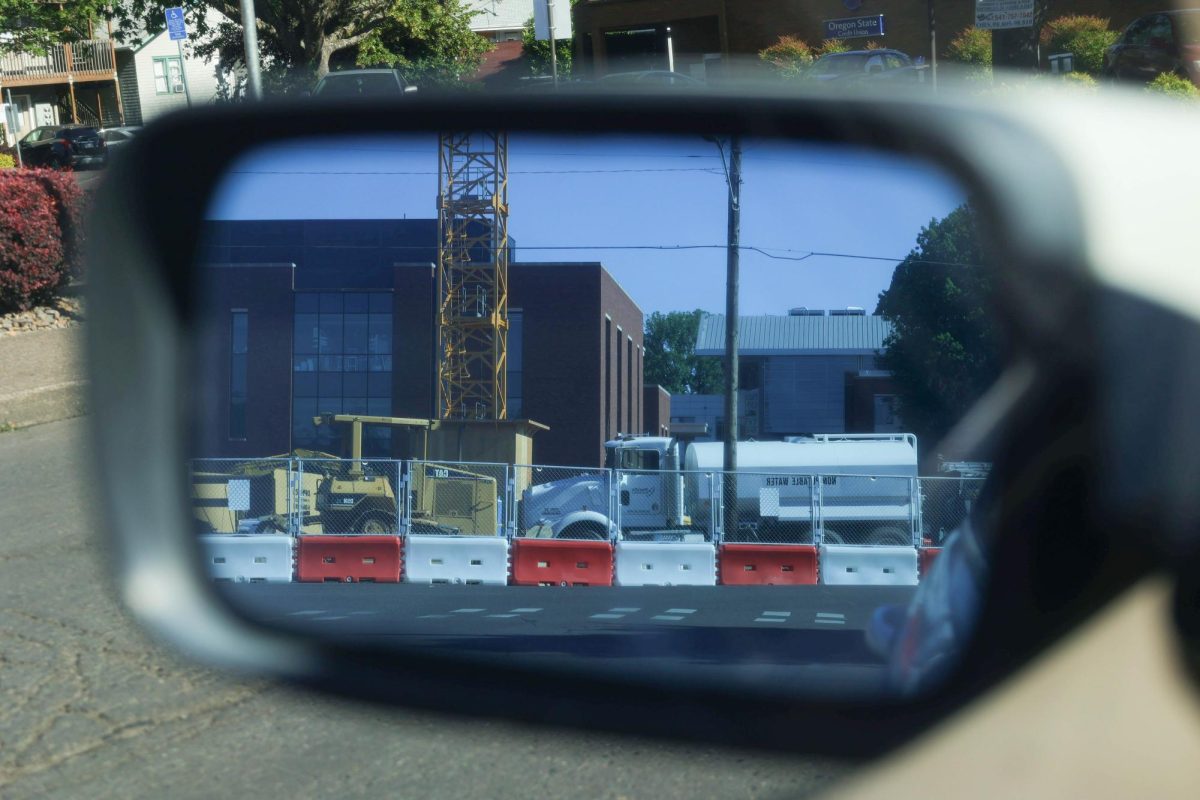 A construction site involved with the construction of Oregon State University’s new computer science building operates through the reflection of a car’s side mirror in Corvallis, OR, on June 19, 2024. 

