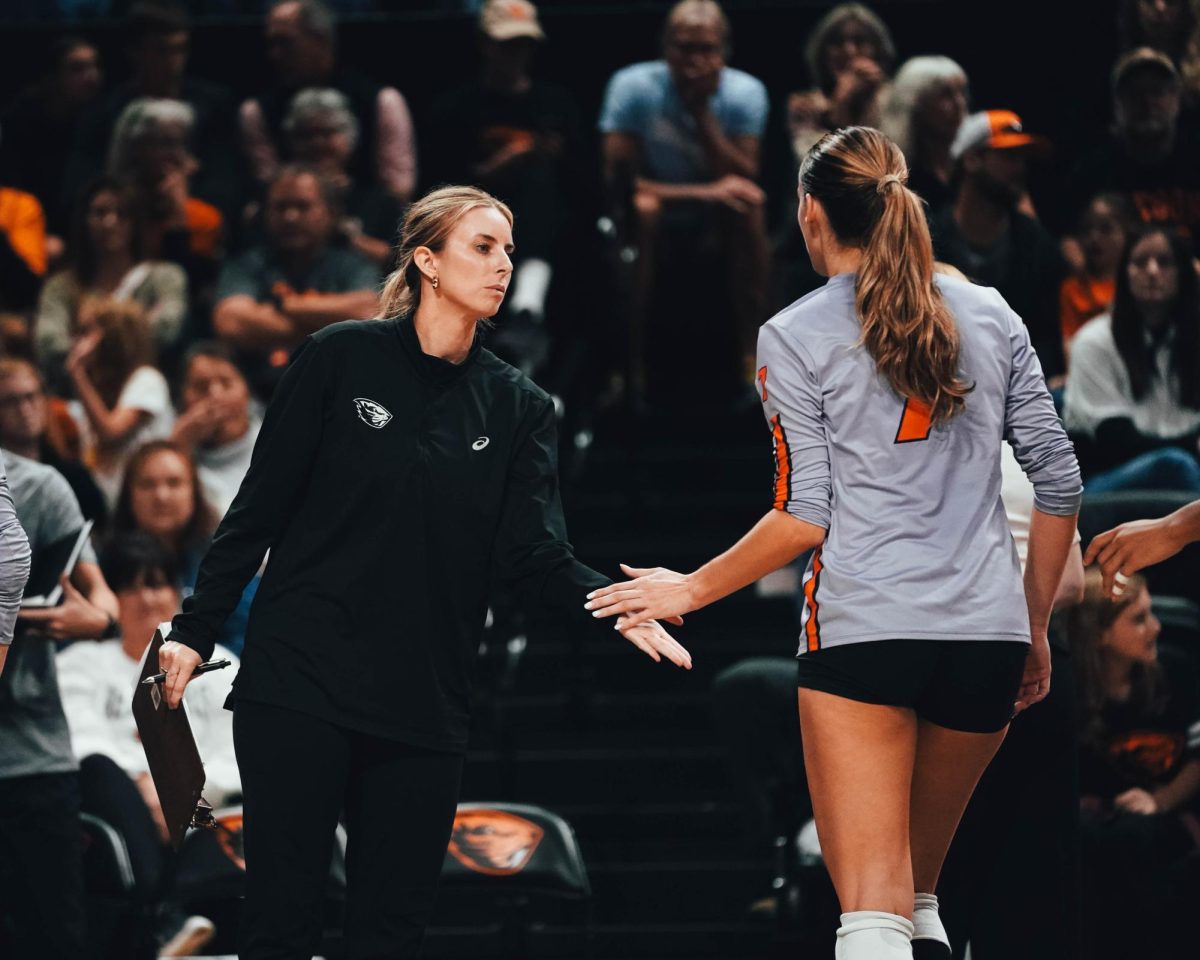 Abbie Wright high-fives player Amanda Burns during a game. 
