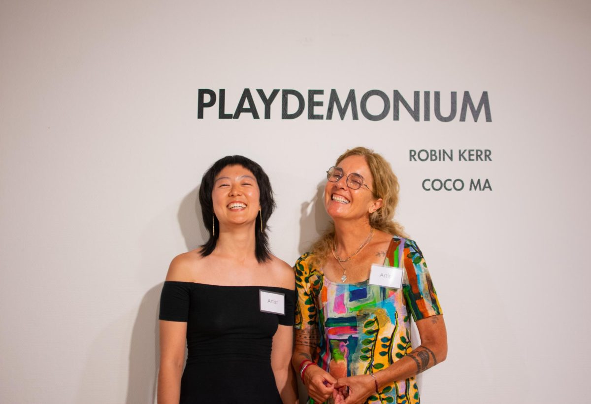 Coco Ma and Robin Kerr smile in front of the Playdemonium exhibition sign in the Corvallis Arts Center in Corvallis, Oregon, July 12. 