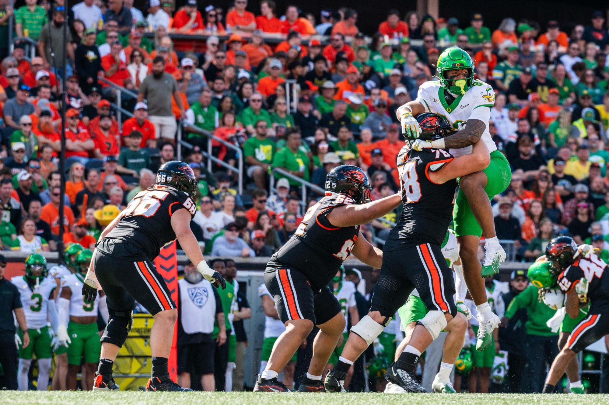 Oregon state player, Nathan Elu (#78) tackles an Oregon Duck, lifting them in the air in a game against UO at Reser Stadium on September 14, 2024 