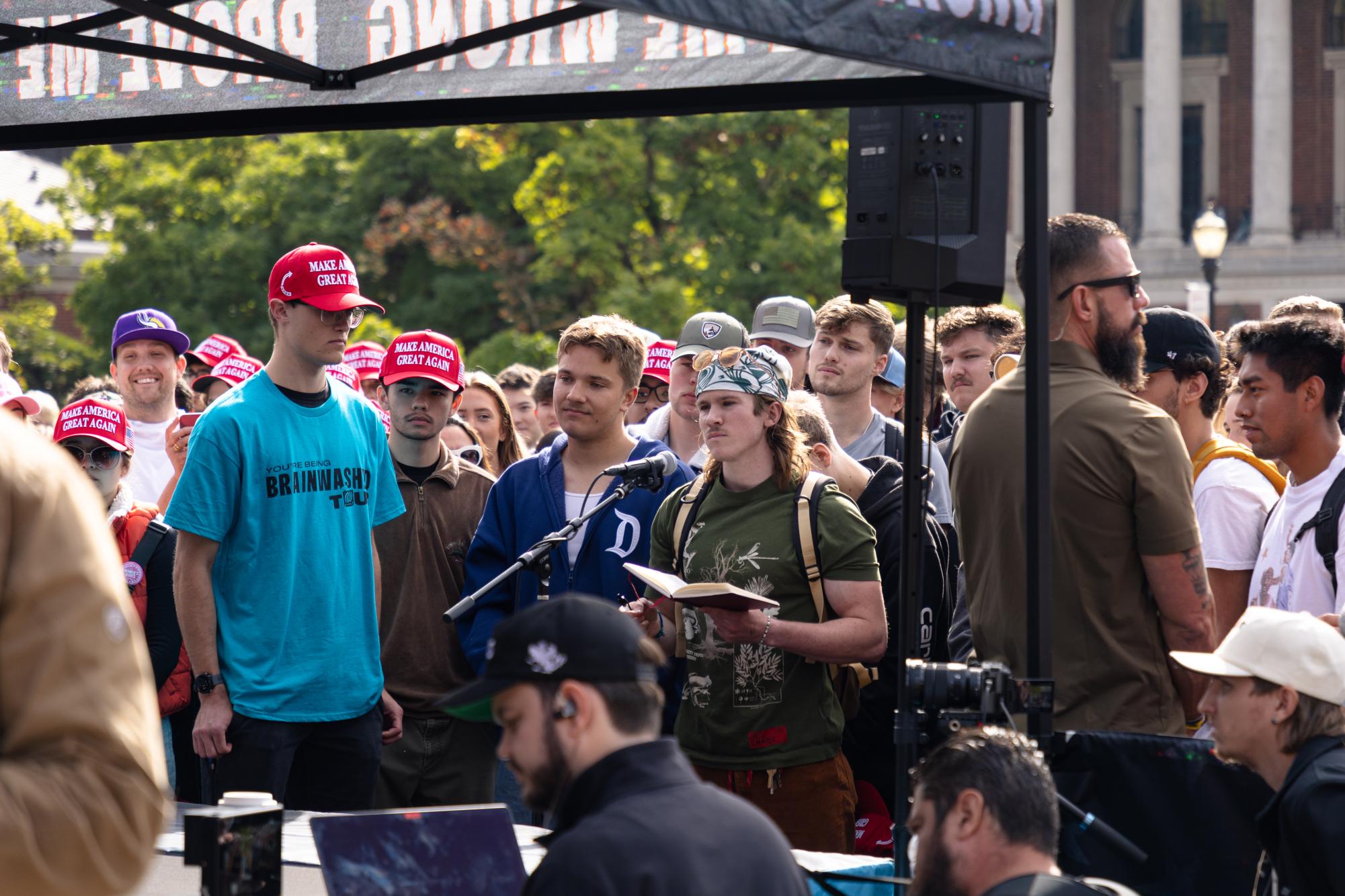 A spectator stands at the microphone with a book of notes and debates Charlie Kirk at the “You’re Being Brainwashed” tour on Oct. 11, at Oregon State University.