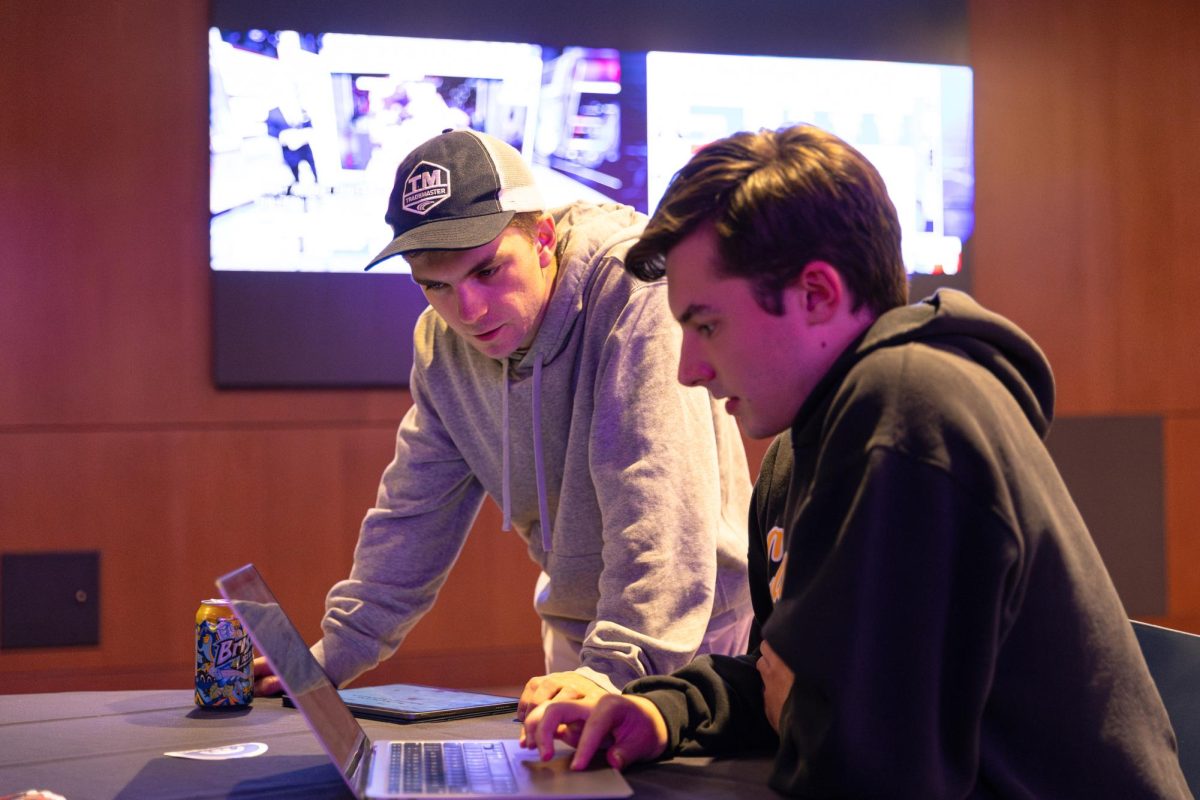 Electrical engineering student Gabe Ryley (left) and psychology student Jonah Davison view incoming 2024 election results on their devices at the Memorial Union Election Night Coverage event on Nov. 5.