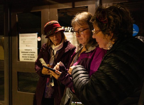 Corvallis residents Pattie Von (left) and Loretta Brenner (right) and another community member gain
access to Margaret Atwood’s online lecture on their phones after the event was cancelled in person at
LaSells Stewart Center in Corvallis, OR, on November 19, 2024.