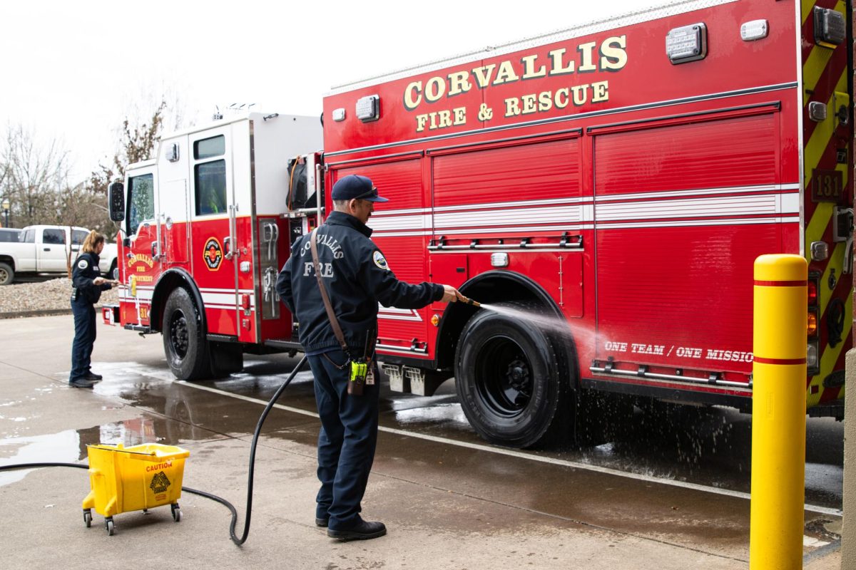 Corvallis fire engineer Casey Stone hoses down an engine with another crew member as per their normal routine on Feb. 6, 2025.