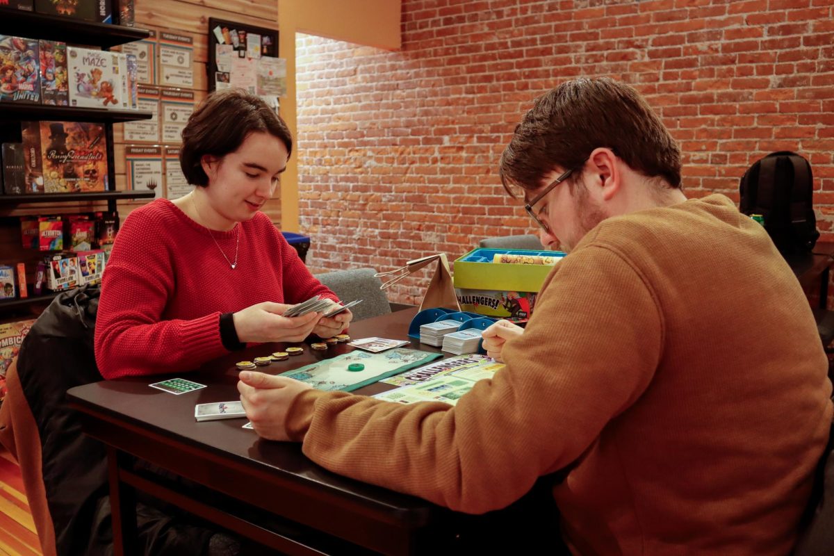 OSU students Reegan Dejong (left) and Jakob Peterson begin to play a new game at Guardian Games on Madison Ave on Feb 5, 2025. Guardian Games offers a space for people of all ages to play classic games, or find a new one.