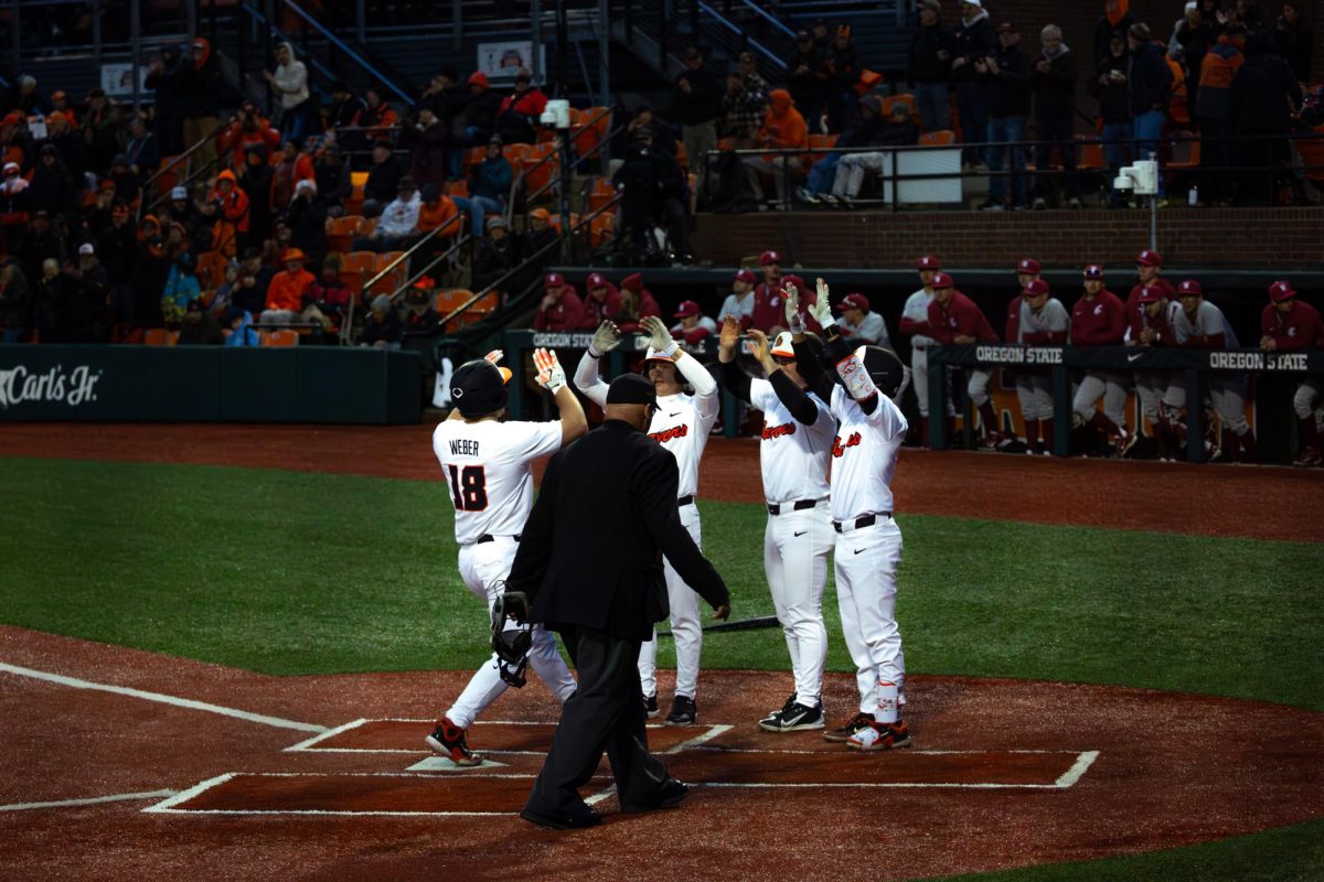 OSU Catcher Wilson Weber (18) celebrates with his teamates at home plate after his 3 run homerun in the 4th inning. The Beavers defeated the Cougars 15-1 at Goss Stadium in Corvallis on March 11, 2025.