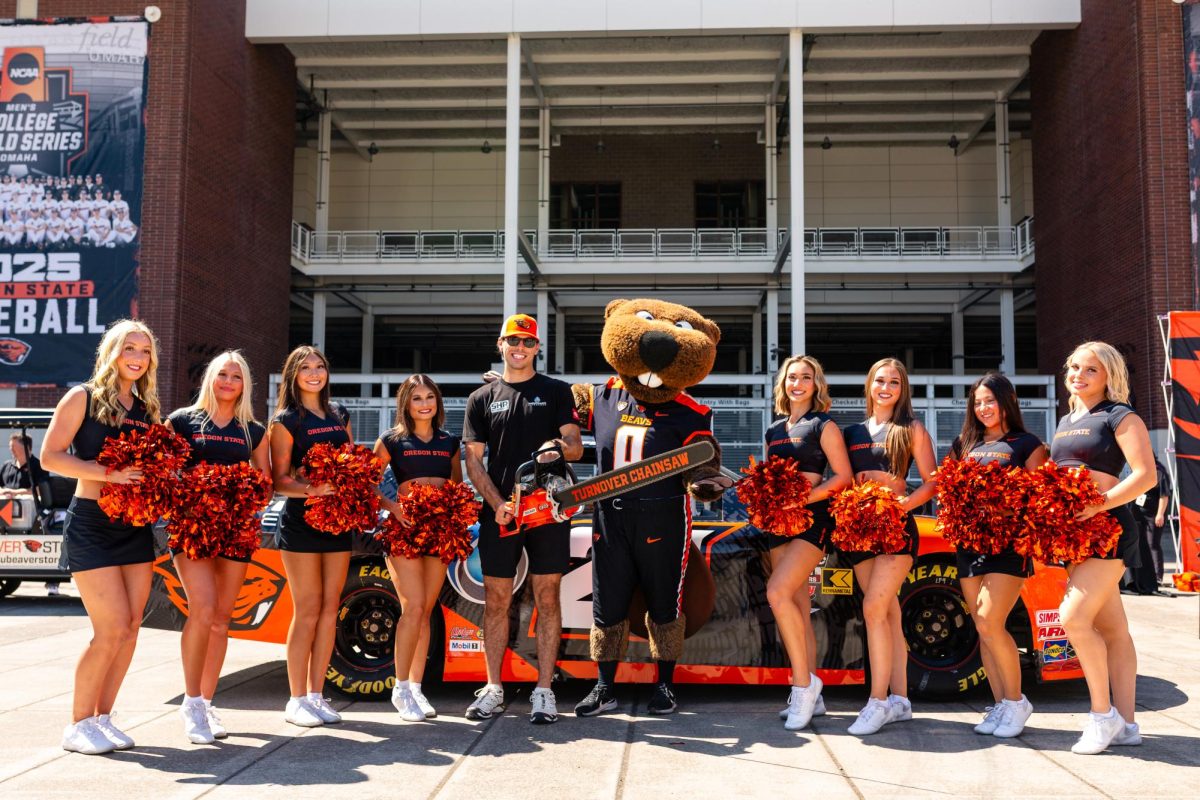 NASCAR driver Dean Thompson posing with Benny the Beaver and OSU Cheerleaders in front of the Oregon State University car Aug. 29, in front of Reser Stadium in Corvallis.