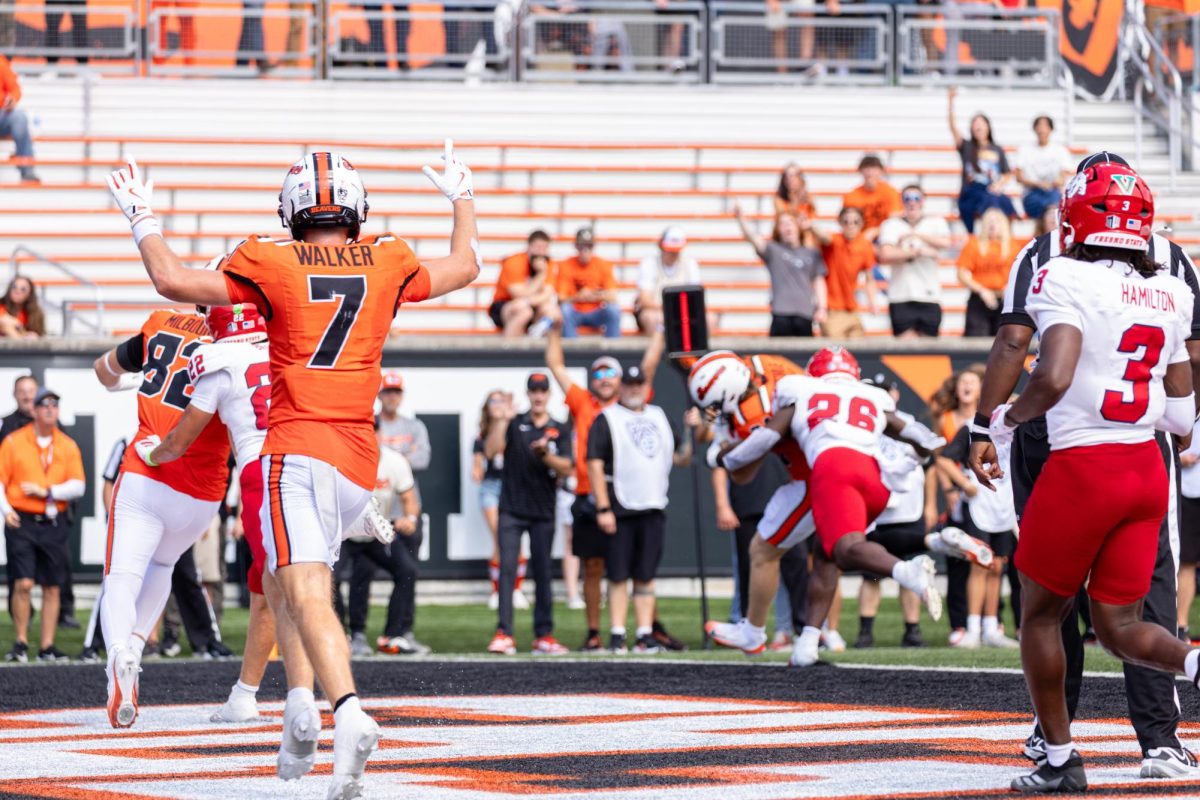 Wide receiver Trent Walker (7) celebrates as running back Jake Reichle (34) makes a touchdown at the game against Fresno State University on Sept. 6, at Reser Stadium.