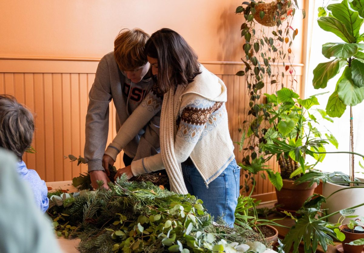 Oregon State Students Alex Jeffries (left) and Mika Juan make a holiday wreath together during the Contemplative Bookstore and Winter Craft Market at the Marigold Center in Corvallis, Ore., Dec. 6, 2025. The center had a few different genres of books to choose from, and a station for making wreaths for the upcoming holiday season. 