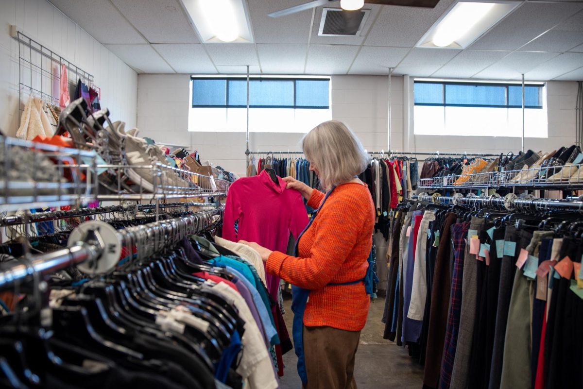 Corvallis Community Thrift floor manager Rich browses a clothing rack at the store on NW Second Street and Jackson Avenue on Jan. 21. Donated items are vetted and cleaned by staff and volunteers.