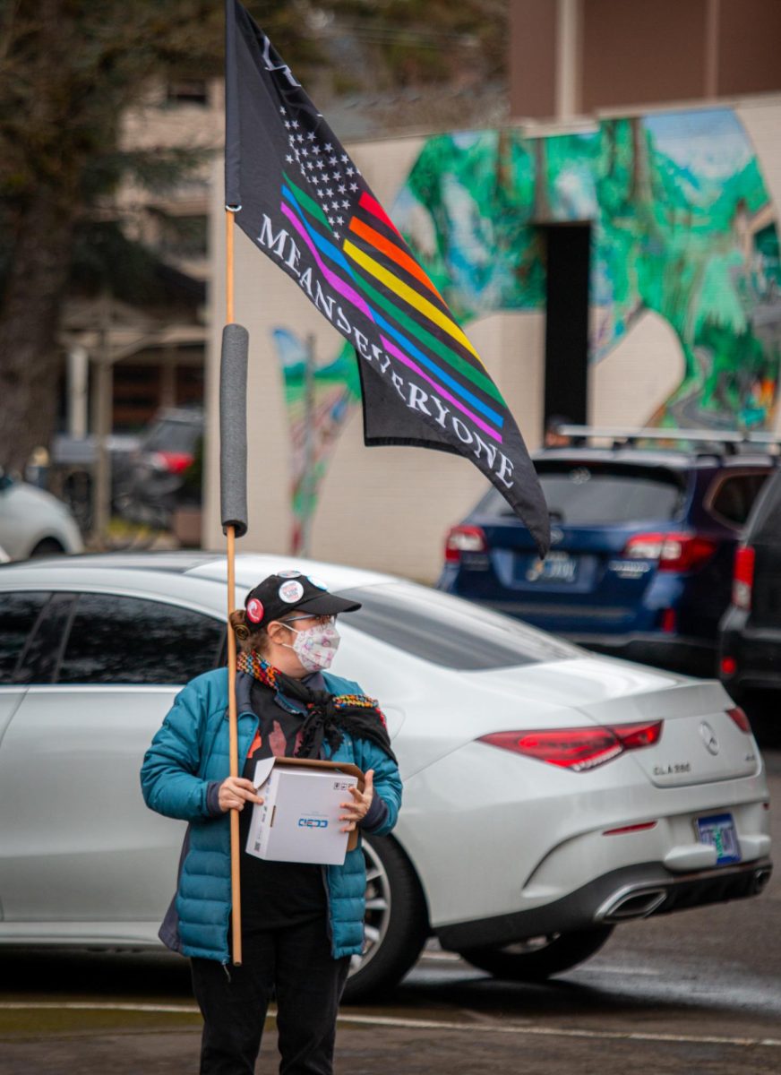 A protester clad in pins and slogans carried a flag displaying the words “We the people means everyone” at the beginning of the demonstration on Jan 30. The walkout, organized by the Party for Socialism and Liberation, was held at the Benton County Courthouse in Corvallis as part of the nationwide anti-ICE general strike.