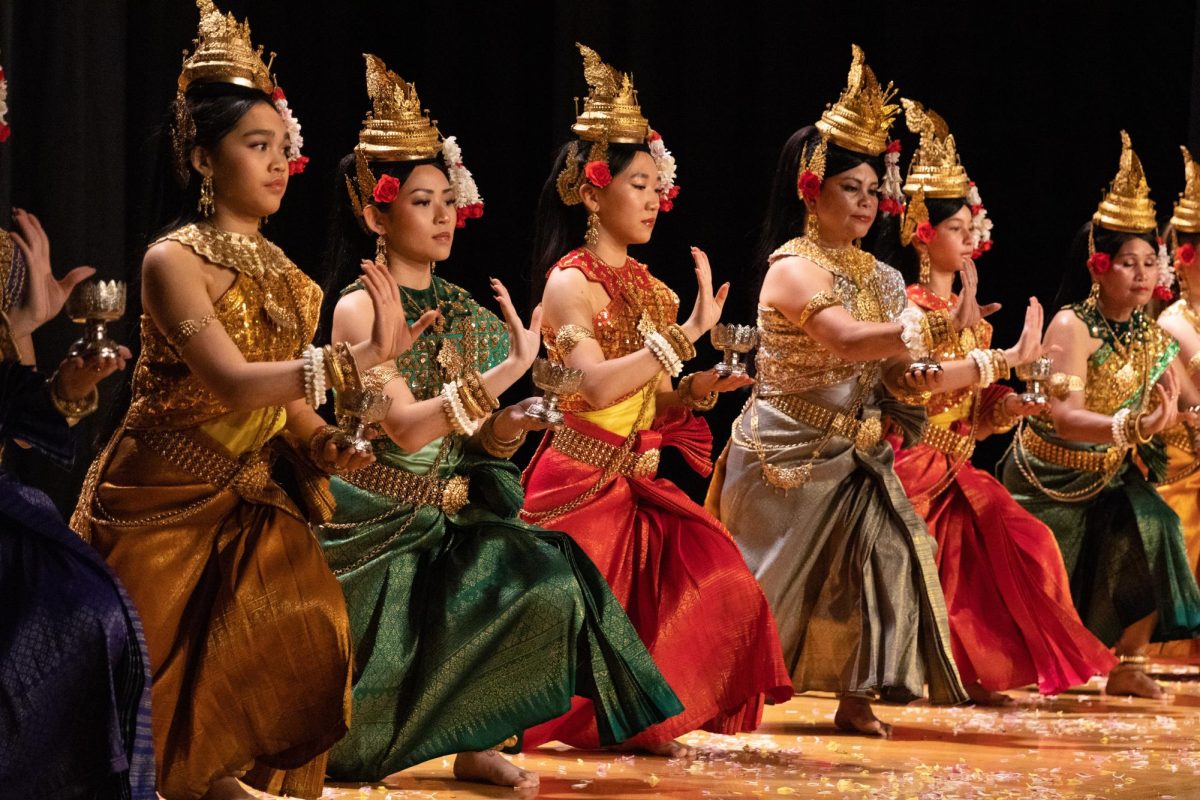 A group of dancers dressed in Cambodian costumes on stage.