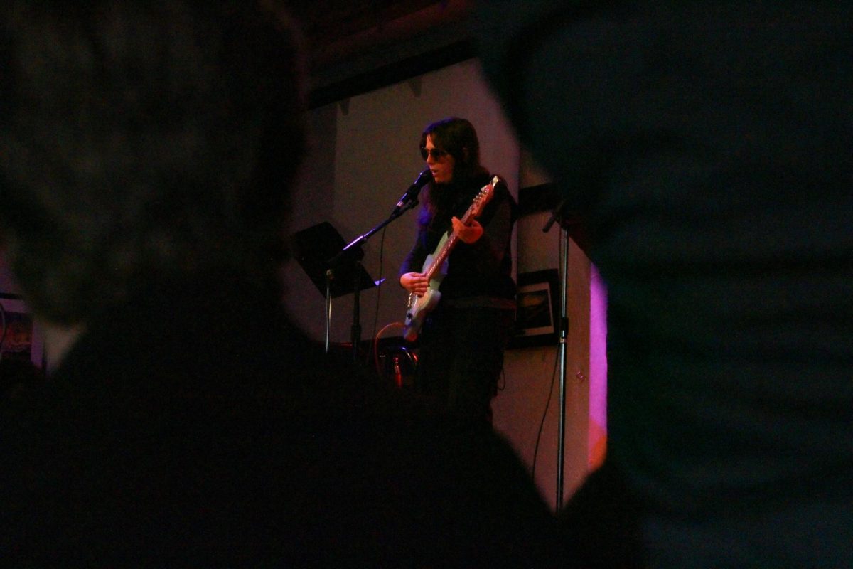 The lead vocalist for the student band, “The Chrissy Bees,” sings an original song.