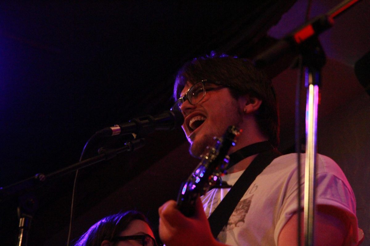 The lead singer for the student band, “The Cuddle Club,” belts out the words to “Rooster,” by Alice In Chains, a song they cover.