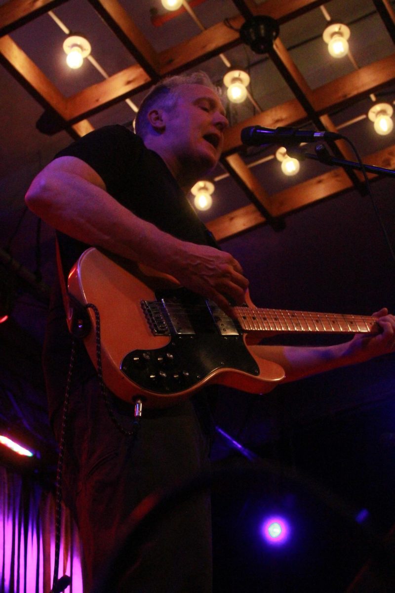 Dr. Chris Bulgren plays guitar alongside other faculty in the Rock Band Showcase.