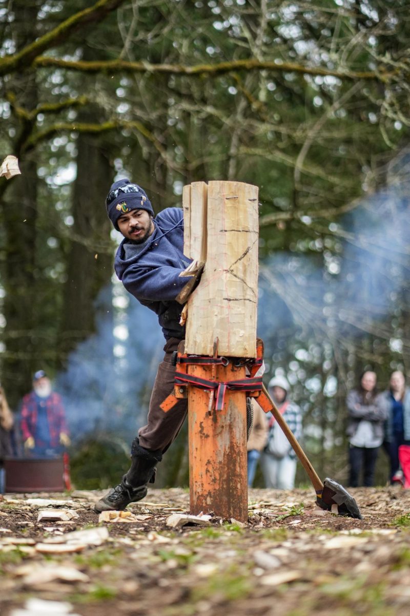 An Oregon State Logging Sports Team memberswings at a standing block
