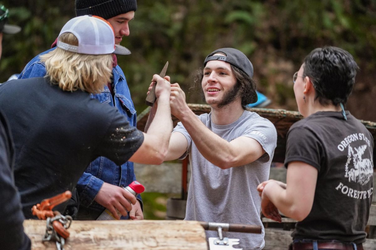 An OSU Logging Sports member fist bumps his teammate