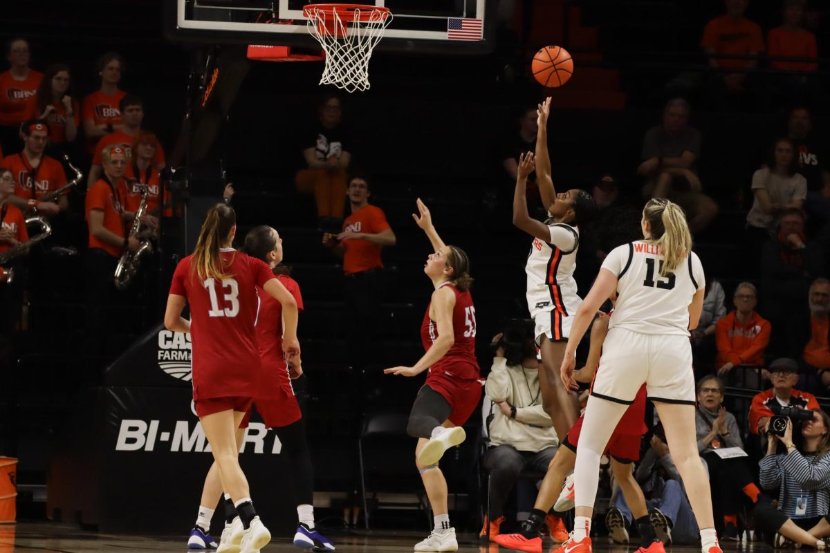 A basketball player jumps and shoots a layup.