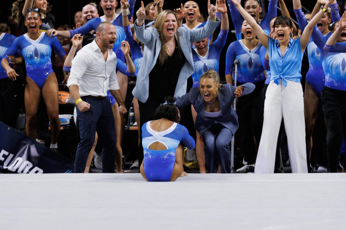 Jordan Chiles and the UCLA Gymnastics team react to her floor routine and celebrate.