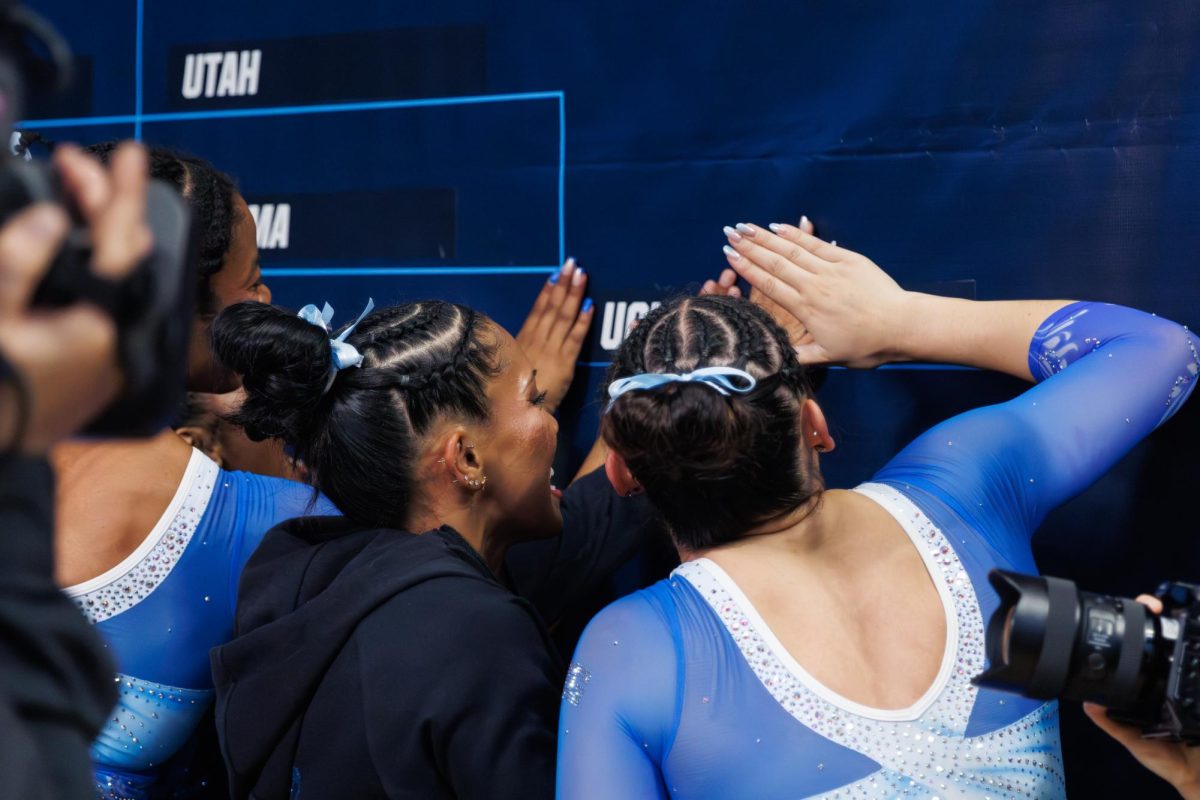 UCLA Seniors Jordan Chiles, Madisyn Anyimi, Carissa Clay and Ciena Alipion place a sticker on the NCAA Corvallis Regional bracket.