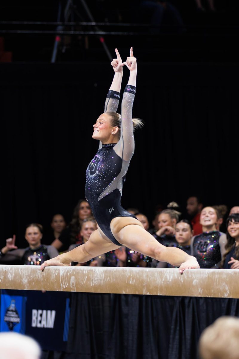 Avery Neff, University of Utah gymnast, holds a middle split during her beam routine.