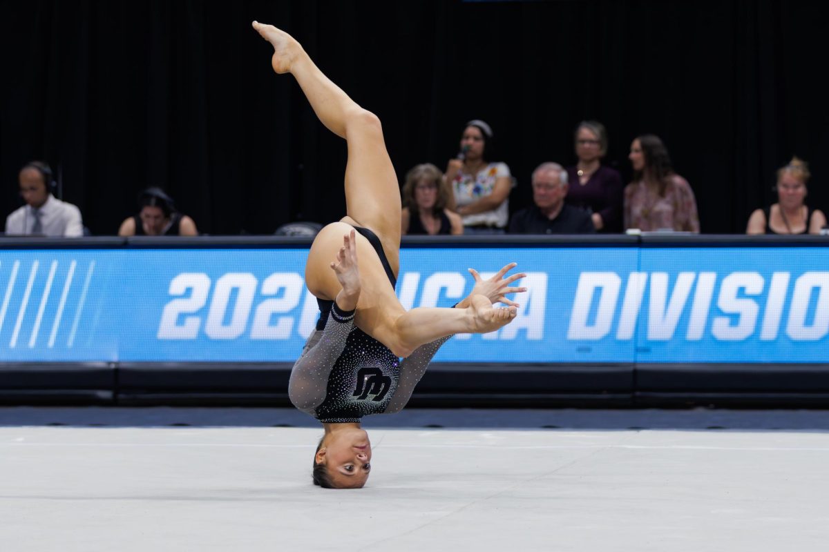 Avery Neff, University of Utah gymnast, holds a pose on her head during her floor routine.