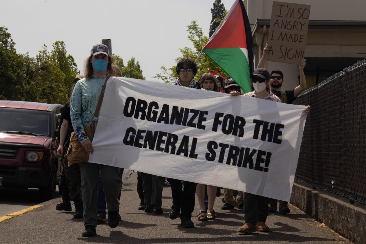 Three protestors hold a banner while marching down the sidewalk.