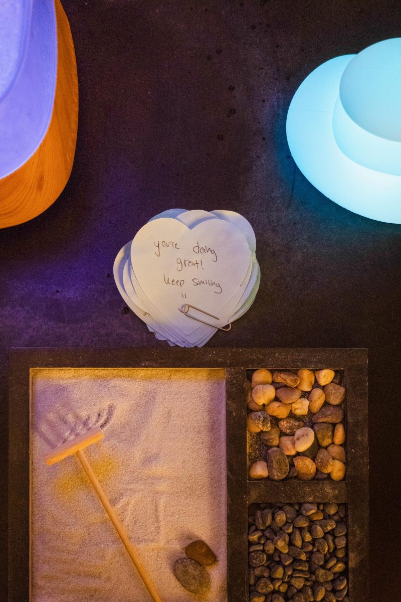 A miniature zen garden and a stack of notes with affirmative messages.