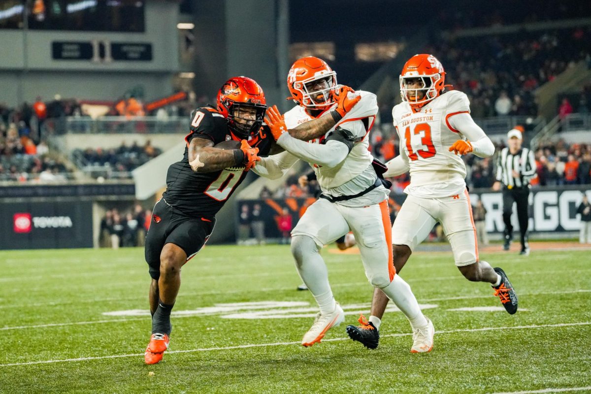 OSU football player on the left runs with the ball away from two Sam Houston players.
