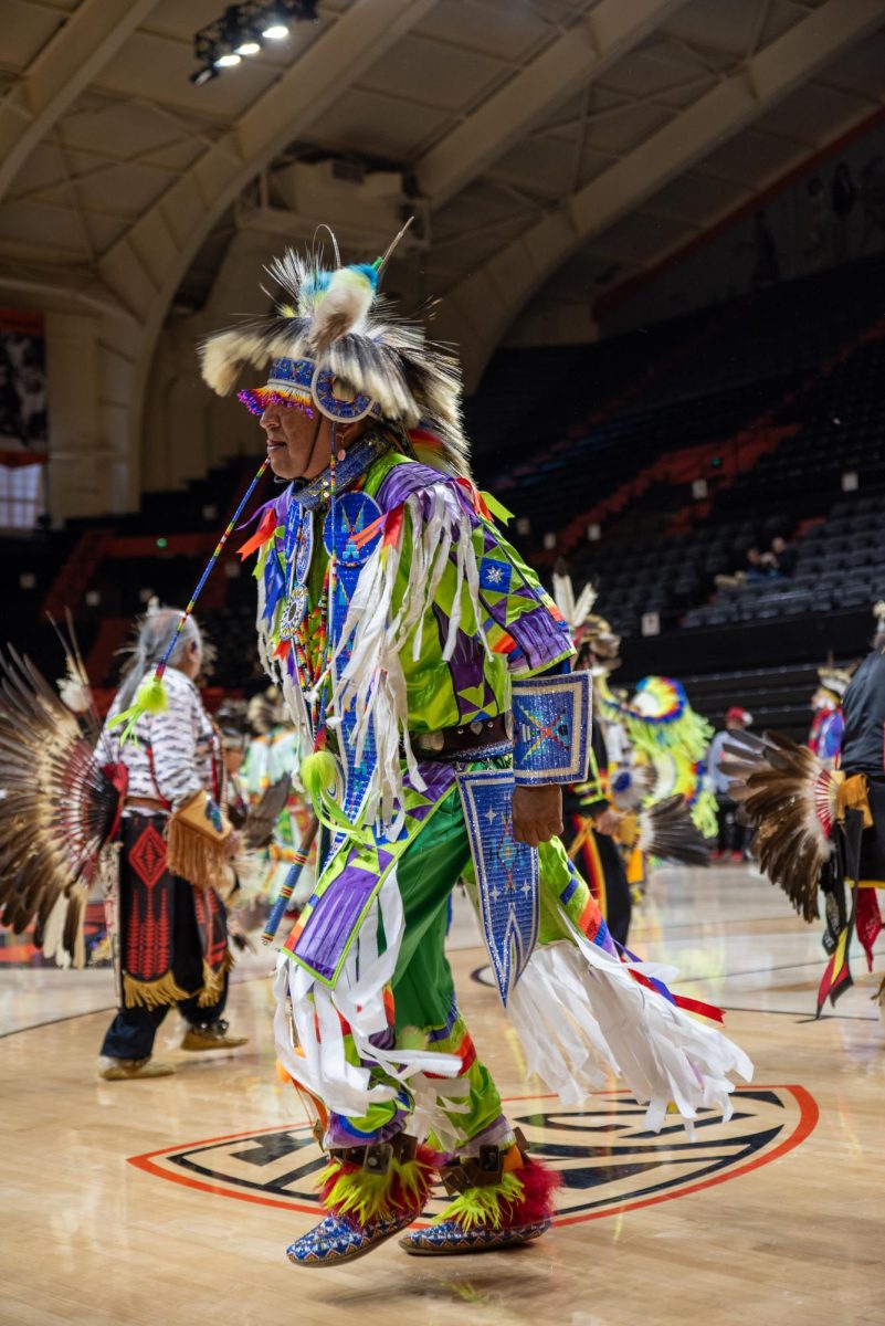 Men in indigenous clothing dance.