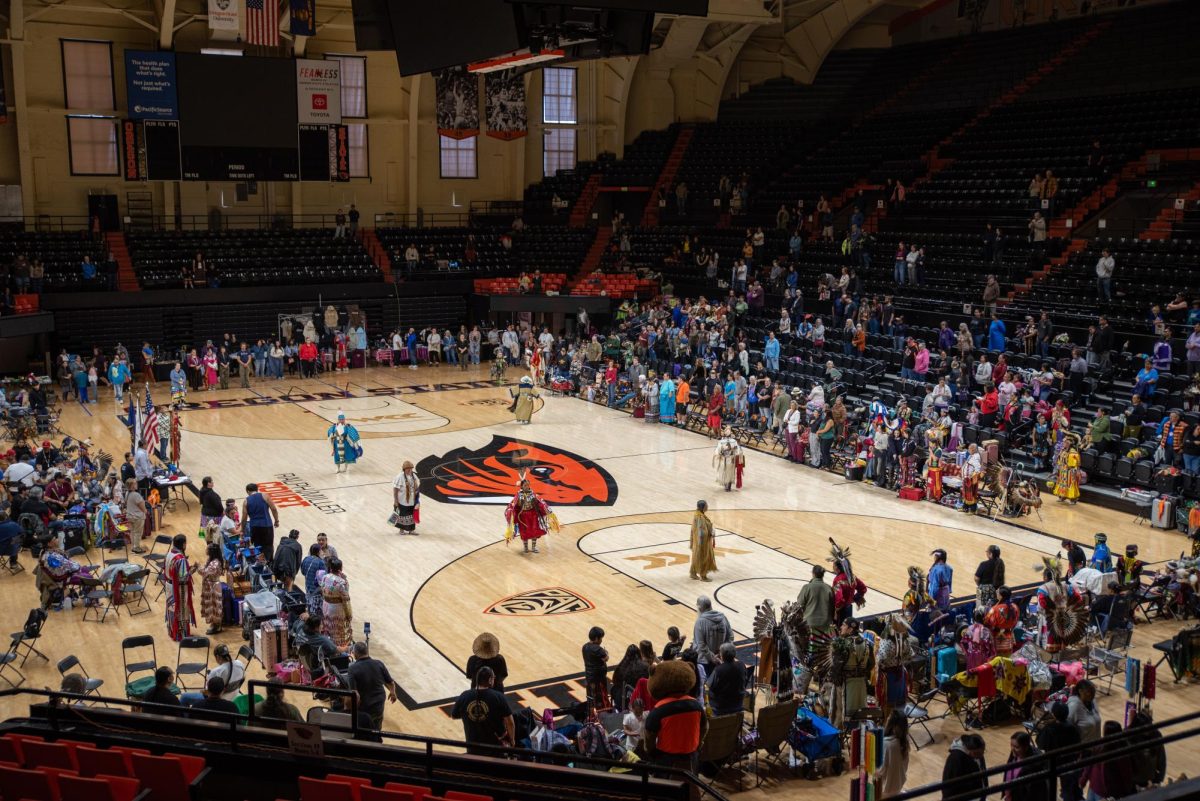 A wide angle photo of women dancing on the court with the audience watching.