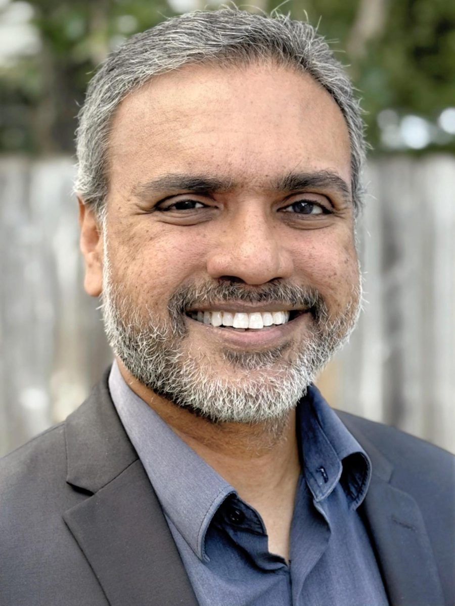 A headshot portrait of a man smiling.
