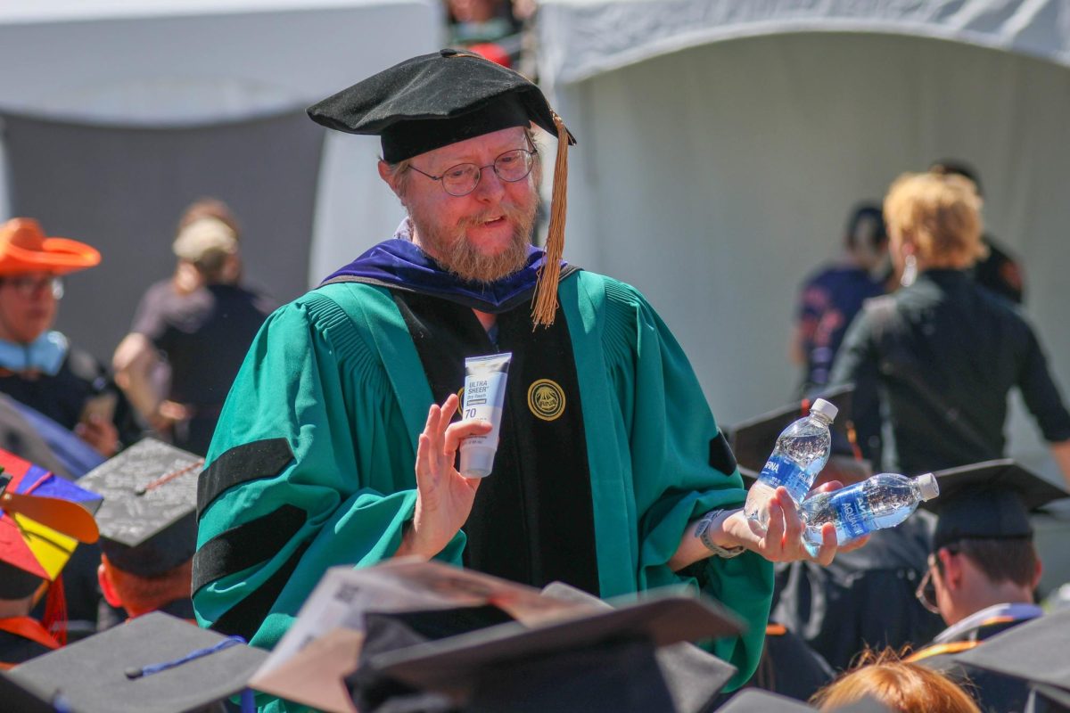 A man holds sunscreen and water.