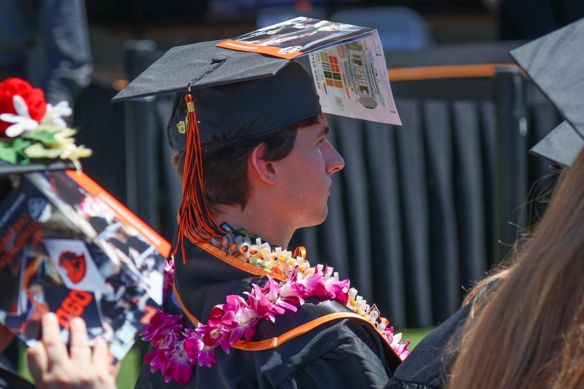 A graduate uses a brochure as a shade for his eyes.