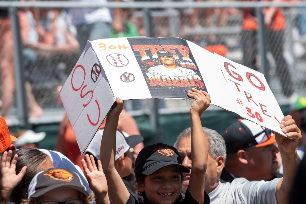 A kid holds up a home made sign for OSU baseball player Trey Morris.