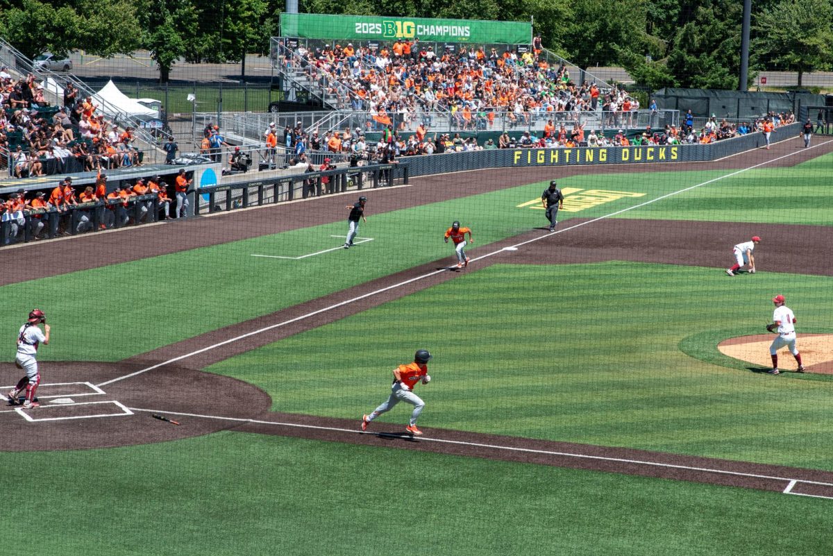 A wide birds-eye view of the field, with OSU players running to first base and home plate.