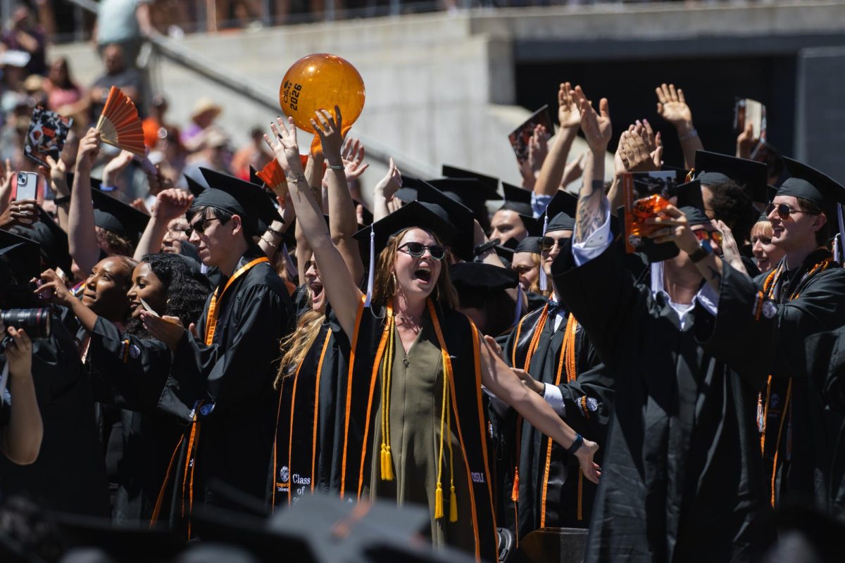 Graduates celebrate and cheer from the field.