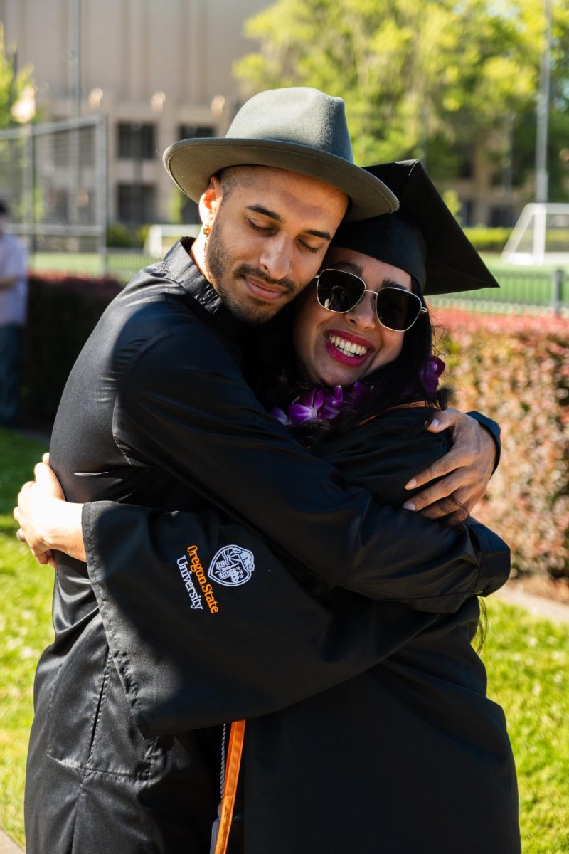 Two people face the camera and hug.
