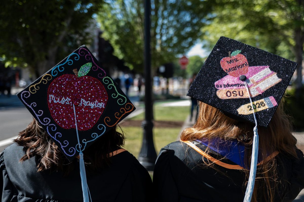 The backs of two graduates heads with their decorated caps on.